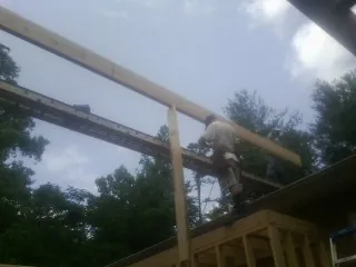 Carpenter setting a ridge beam over a new addition frame — Ice Dam Removal by Roofing Brothers in Bohemia