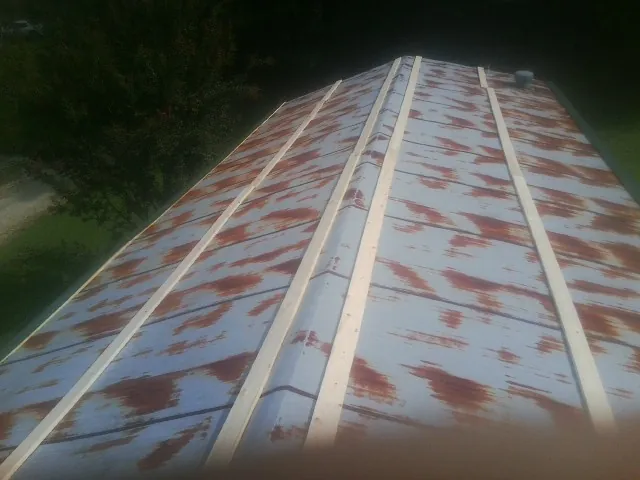 Rusted metal roof panels with new wood purlins before replacement — Storm Damage Roof Repair in Bohemia by Roofing Brothers