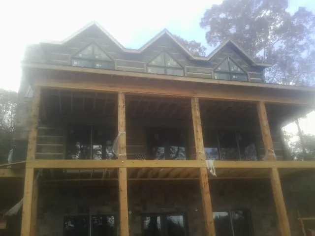 Dormers and porch framing on a large log home under construction — Roof Coating work by our crew in Bohemia