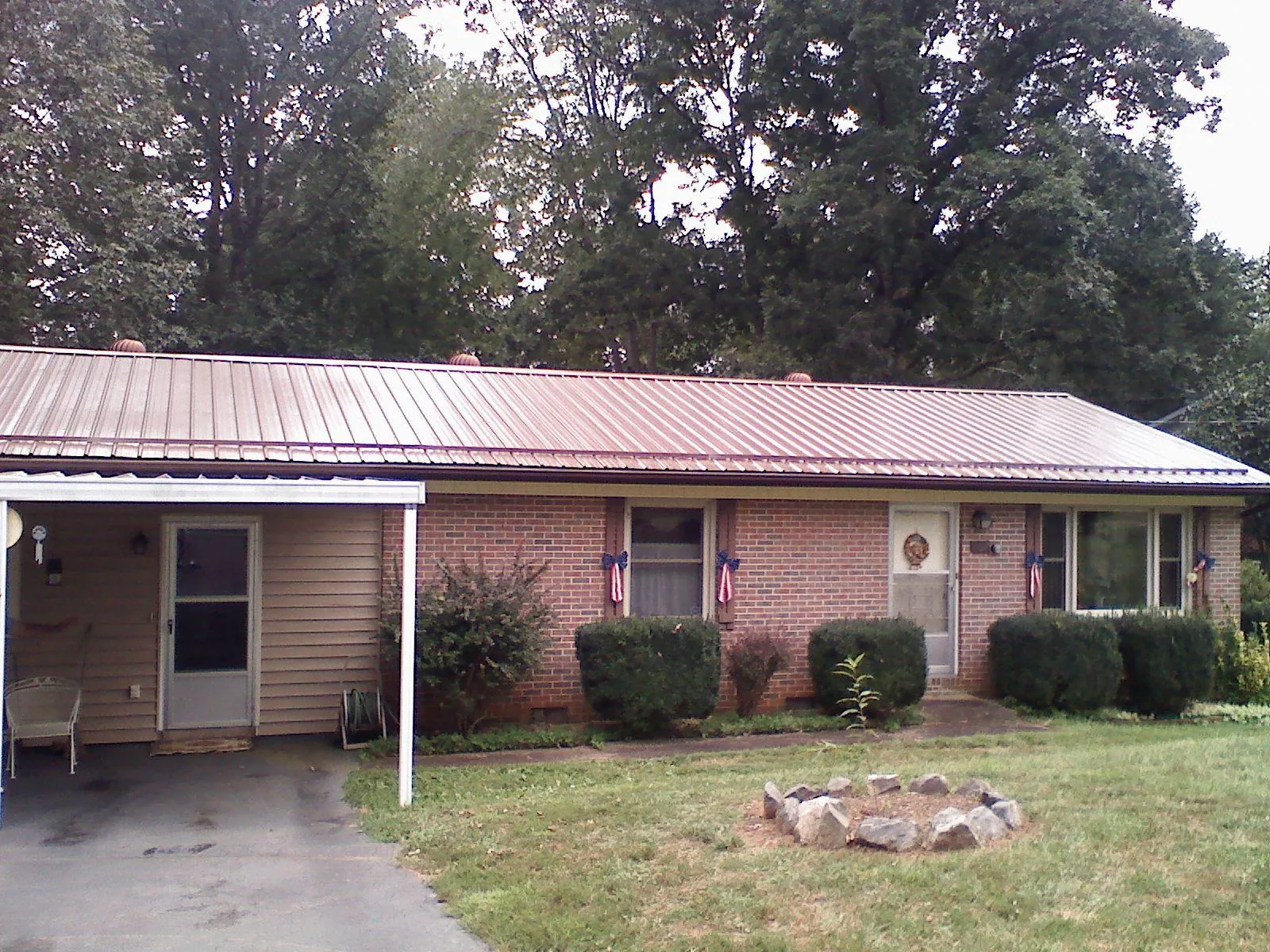 Bronze metal roof and carport on a brick ranch home — Roof Repair work by our crew in Bohemia